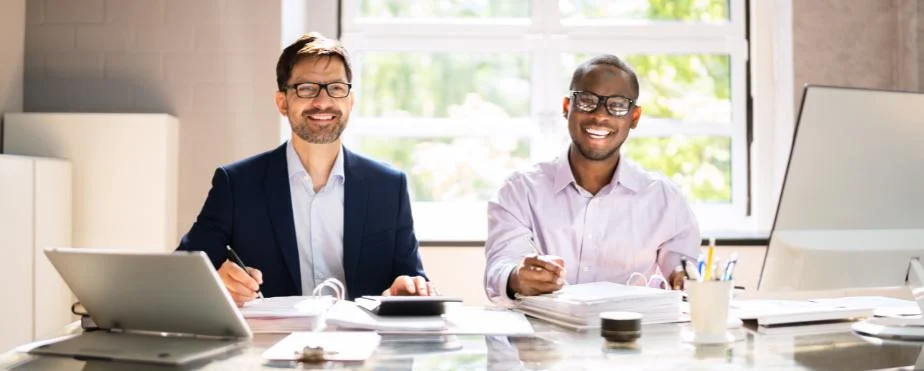 Two CPAs facing the camera smiling for hospitality accounting work